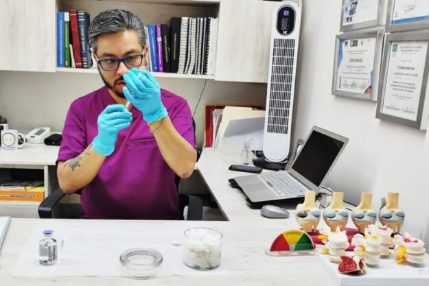 Doctor especialista en dolor de ciatica en satélite preparando tratamiento intervencionista para paciente