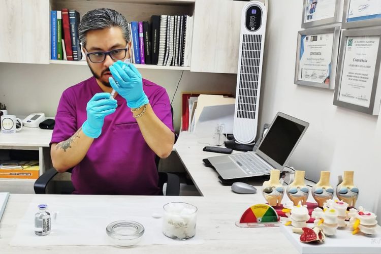 Doctor especialista en dolor de ciatica en satélite preparando tratamiento intervencionista para paciente